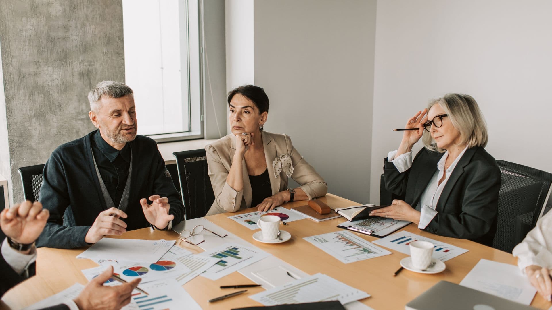 Business colleagues discussing documents around a meeting table