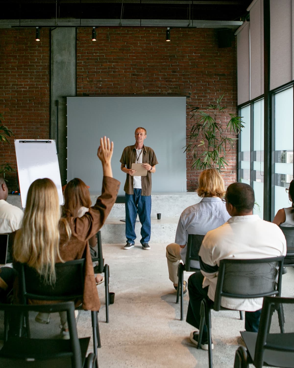 Participants raising their hands during a facilitated workshop; illustrative stock photo